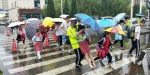 点赞！雨天交警将百名学生抱进校园 - 正北方网